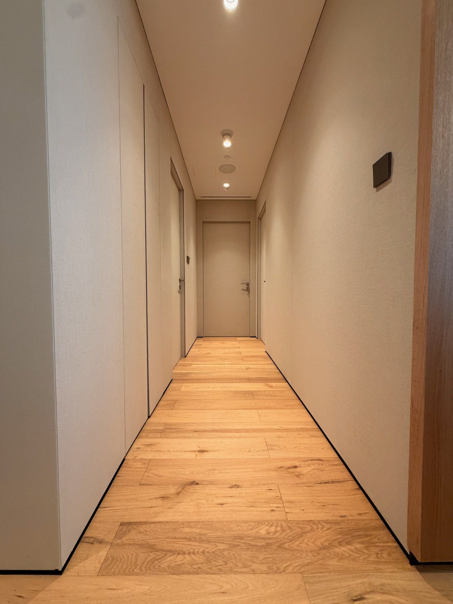 Corridor lined with fabric wall panels and a warm floor light line